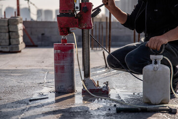 Drilling reinforced concrete floors with an automatic electric drilling rig. - obrazy, fototapety, plakaty