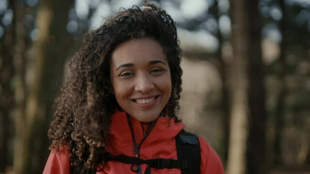 Girl travels through the natural park on foot. Hiking in woods. Girl tourist hike with backpack. portrait to camera. selfie. Woman travels outdoors with a backpack. Hiking in the mountain