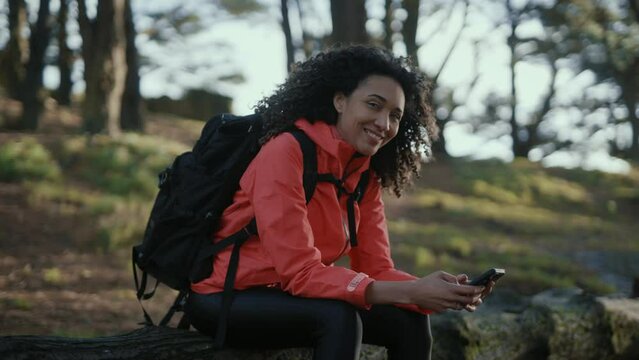 Girl travels through the natural park on foot. Hiking in woods. Girl tourist hike with backpack. portrait to camera. selfie. Woman travels outdoors with a backpack. Hiking in the mountain