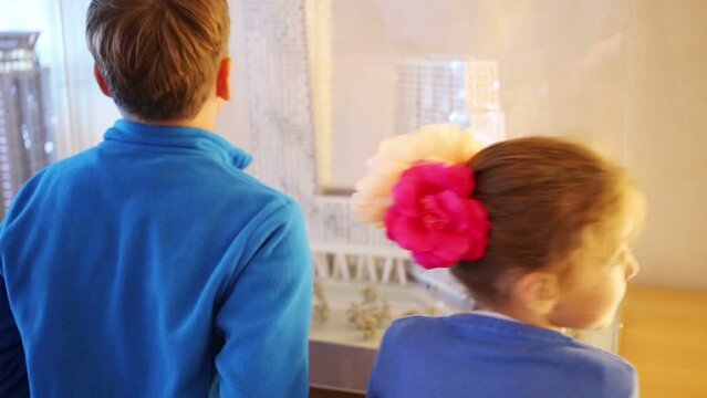 Back of boy and girl looking at layout of area with buildings