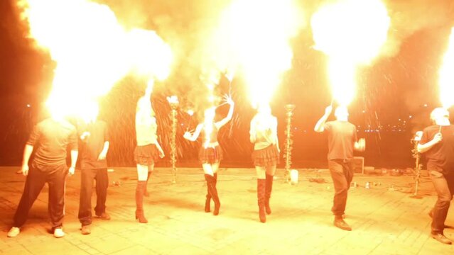 Group of boys and girls makes spurt fire at evening show.