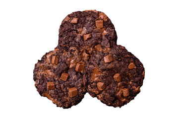 Delicious fresh oatmeal round cookies with chocolate on a black ceramic plate