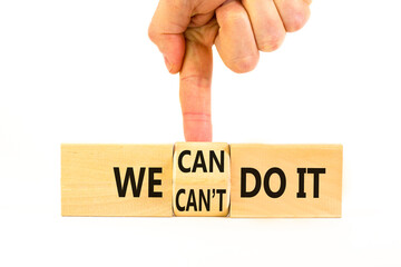 We can do it symbol. Concept word We can or can not do it on beautiful wooden cubes. Beautiful white table white background. Businessman hand. Business and we can or not do it concept. Copy space.