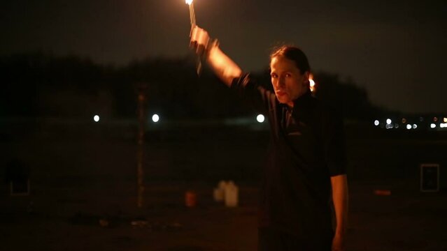 Boy counts down and makes fireball at fire show in evening.