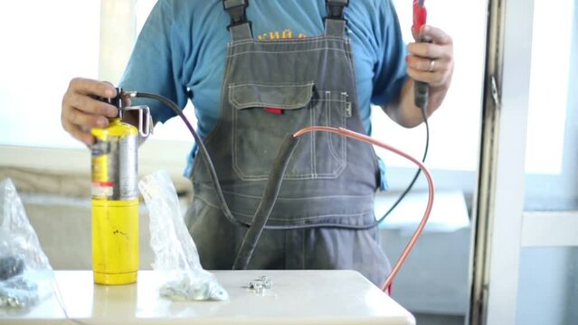 Young worker welds copper tube oxyfuel gas welding 