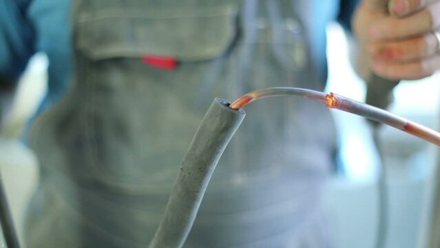 Hands of worker welding copper wires for air conditioner