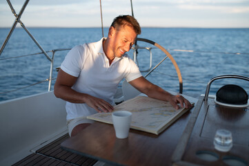 Good-looking positive man on a yacht feeling good