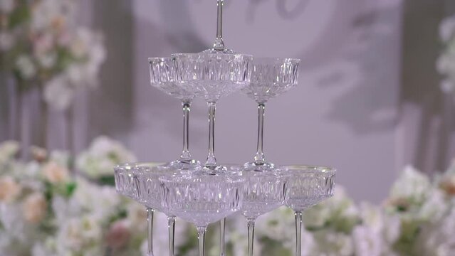 Tower of glasses at celebration party. Welcome drinks, tower of champagne or sparkling wine. Empty with red berry. Restaurant ready for reception. Alcoholic beverage.