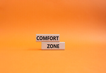 Comfort zone symbol. Concept word Comfort zone on wooden blocks. Beautiful orange background....