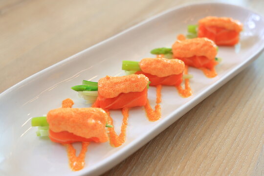 Japanese fusion food Salmon with mentaiko source Serving on white plate.