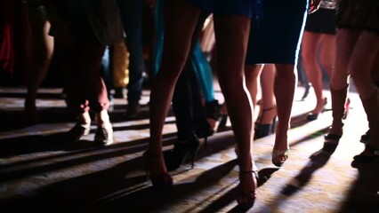 Slender legs young women have fun and dance at party