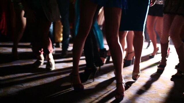 Slender legs young women have fun and dance at party