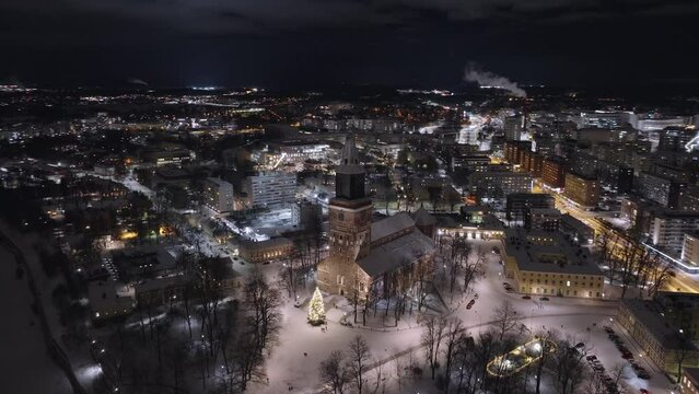 Aerial night view of the medieval Turku Cathedral with big Christmas tree in December, parallax shot