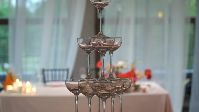 Tower of glasses at celebration party. Welcome drinks, tower of champagne or sparkling wine. Empty with red berry. Restaurant ready for reception. Alcoholic beverage.