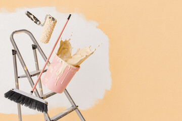 Paint roller and brush in mid-air with a bucket tipping over on a ladder, spilling paint, against a half-painted wall with copy space.