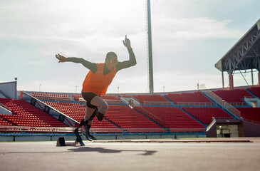 Sport man athlete prosthesis legs start run with look forward at the stadium with soft light of...