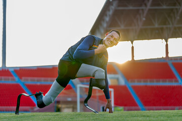 Close up side view sport man athlete prosthesis legs stay in the position of stretching also look...
