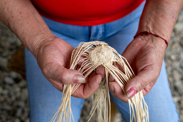 Hands of a woman starting to weave a hat