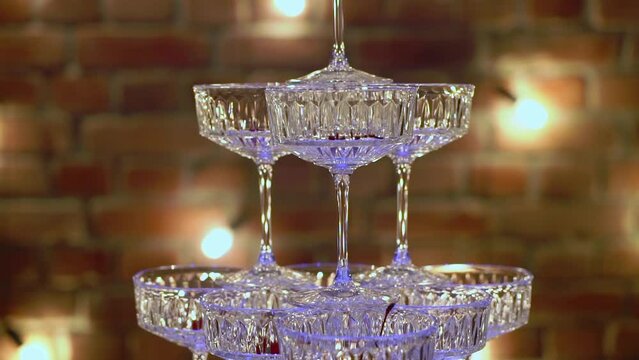 Tower of glasses at celebration party. Welcome drinks, tower of champagne or sparkling wine. Empty with red berry. Restaurant ready for reception. Alcoholic beverage.