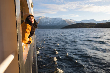 happy adult woman leaning on the railing of the boat at sunset over the ocean - empowered woman...