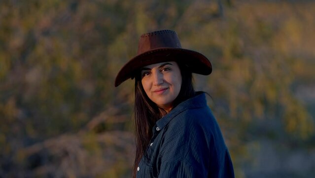 Portrait shot of a young cowgirl wearing a cowboy hat posing for the camera - travel photography
