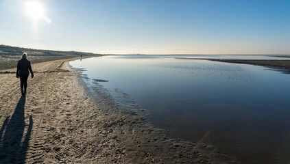 Sunny December stroll on the Zandmotor Beach of Kijkduin near The Hague during high tide.