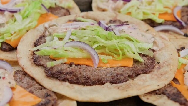 Homemade Taco smash burger with sauce, cheese, lettuce and red onion. Rotating video