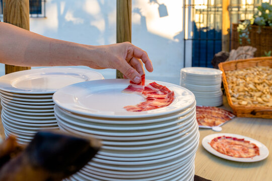 Colocando jam&oacute;n en el plato reci&eacute;n cortado