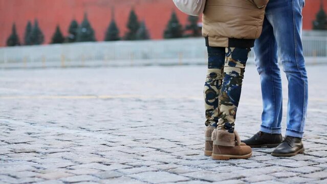Legs of young man and woman which met on paved square