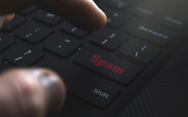 Close up of hand clicking Spam button. Internet concept for spam