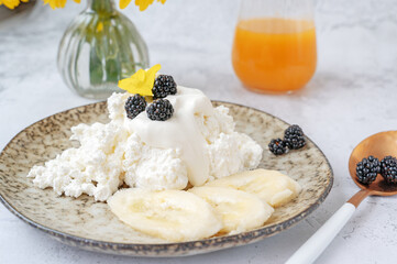 Farm fresh cottage cheese with berries and banana slices. Early breakfast of cottage cheese with...