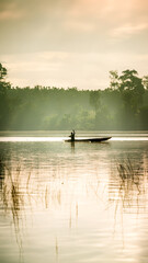 Portrait of fishermen preparing to fish in a reservoir or lake with a canoe or wooden boat.