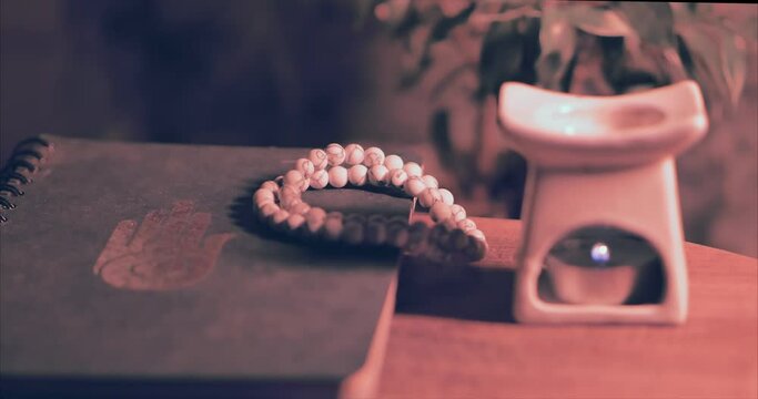Meditation. Aromatic white lamp, white beads and a notebook with the symbol of AHIMSA