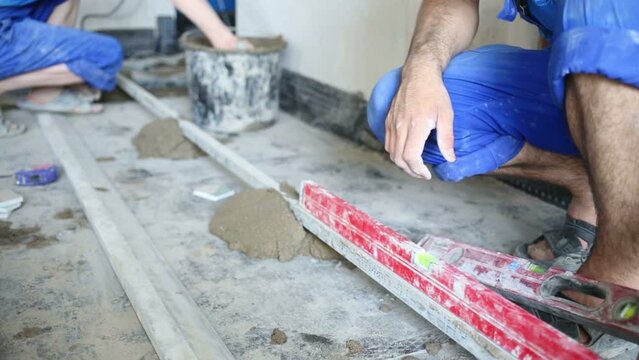 Worker verifies metal framework element for pouring floor
