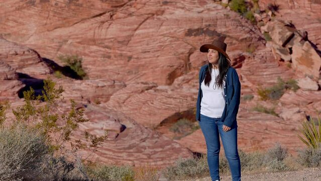 Young woman in a western style outfit exploring the amazing Red Rock Canyon in Nevada - travel photography