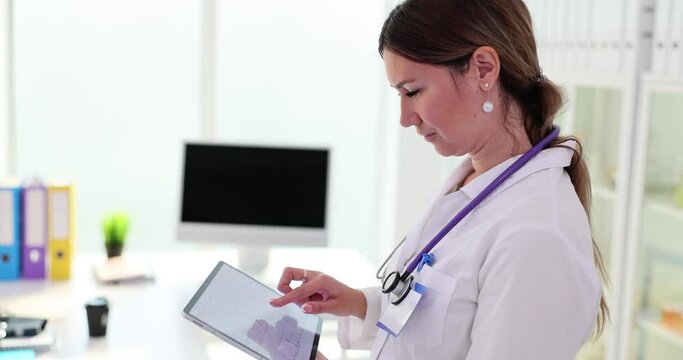Doctor holds digital tablet with cardiogram in clinic