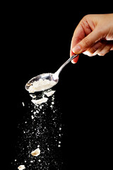 Flour fall down in air. Black background Isolated, selective focus