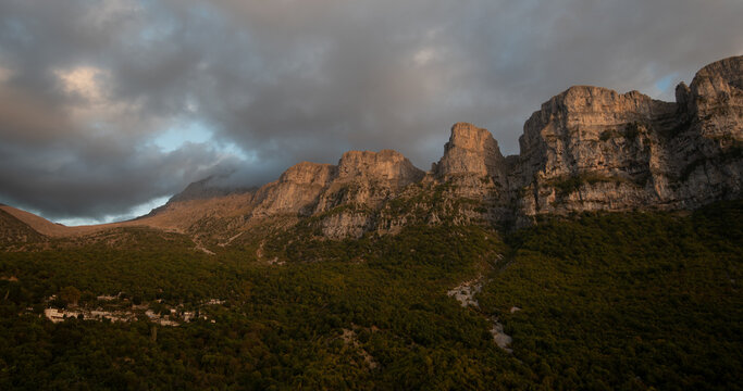 Drone scenery mikro Papingo village , Zagorochoria area, Epirus, Ioannina Greece. Astraka tower rocky cliffs above the village at sunset