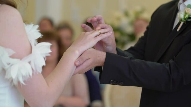 Bride and groom at wedding ceremony. Man put on a ring on a woman finger. Exchange jewelry rings, symbol of love.
