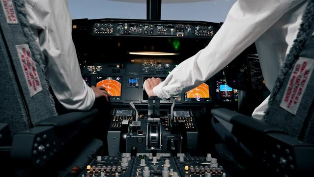 rear view of pilots in the cockpit of an airplane during flight control in a turbulence zone flight simulator