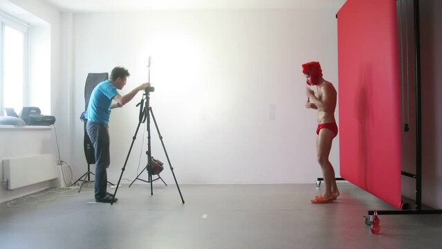 Work in the studio: photographer shooting a young guy who sings