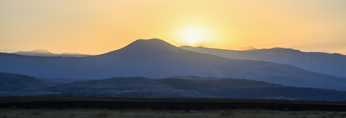 Sunset landscape field and mountains.