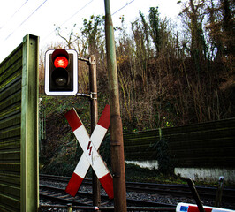 traffic light is red and the barrier is closed at the railway crossing