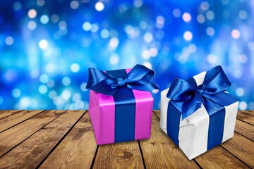 Christmas gift with ribbon bow at bokeh background.