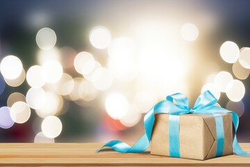 Christmas gift with ribbon bow at bokeh background.