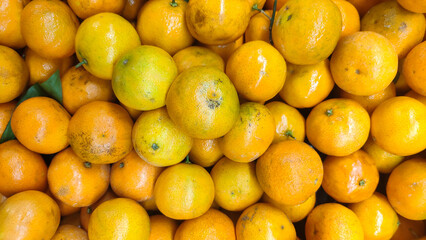 Ripe tangerines on the market. Citrus fruits background. 