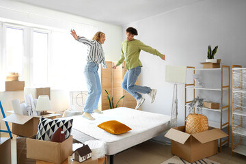 Young couple jumping in bedroom on moving day