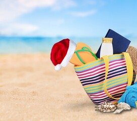 Santa hat with summer accessories on beach.