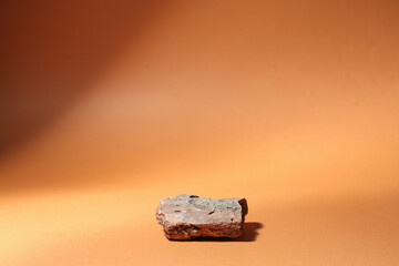 Decorative stone podium on brown background