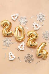 Composition with figure 2024 made of golden foil balloons and Christmas decorations on color background